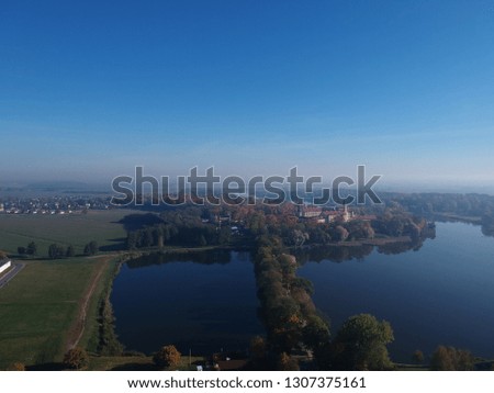 Drone photo of Nesvizh Castle from across the pond on a hazy autumn day. Minsk Region of Belarus. 