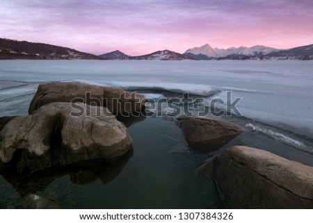 Enchanted view of frozen Campotosto lake in winter at sunset, Abruzzo