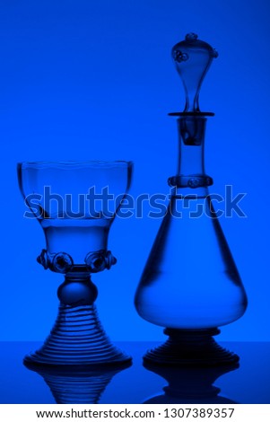 Middle age rummer wine glass and bottle on the white background. Black and white, monochrome picture.