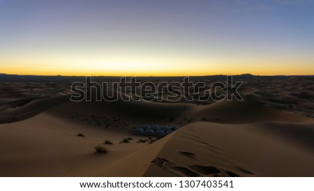 A camp among the dunes of the Sahara Desert, near Merzouga, Morocco - known as a gateway to Erg Chebbi, a huge expanse of sand dunes north of town. Photo's taken at sunrise. Day trip.