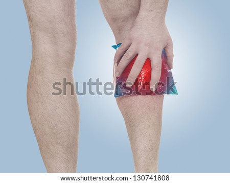 Acute pain in a man calf. Male holding ice pack  on calf-aches. Medical concept photo. Isolation on a white background.
