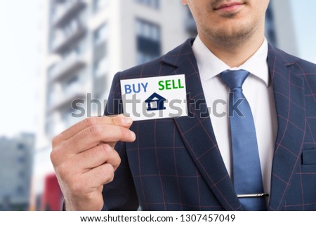 Real estate agent presenting white business card with house symbol and buy sell text as advertising concept