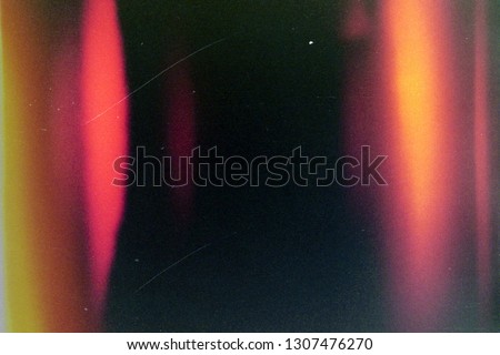 Blank grained and scratched film strip texture background with heavy grain, dust and a light leak Real Lens Flare Shot in Studio over Black Background. Easy to add as Overlay or Screen Filter  Royalty-Free Stock Photo #1307476270