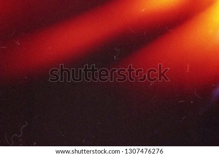 Blank grained and scratched film strip texture background with heavy grain, dust and a light leak Real Lens Flare Shot in Studio over Black Background. Easy to add as Overlay or Screen Filter  Royalty-Free Stock Photo #1307476276