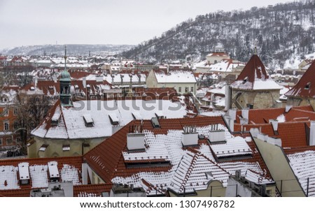 
Prague in winter time, view on snowy roofs with historical buildings