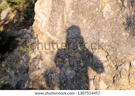 the shadow of the photographer on the stone surface of the cliff in the summer or photographer taking pictures of his shadow