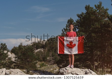 
Child teenager girl holding a Canada flag at nature background