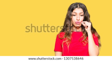 Young beautiful woman wearing casual t-shirt mouth and lips shut as zip with fingers. Secret and silent, taboo talking