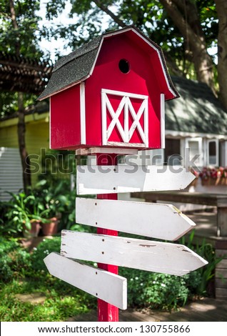Red wood Mailbox with White sign.in a farm.