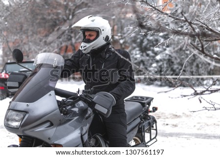 Rider man in action on adventure motorcycle. Winter fun. snowy day. ride on snow road. off road. dual sport travel tour, active life style concept. winter clothes, equipment, copy spase