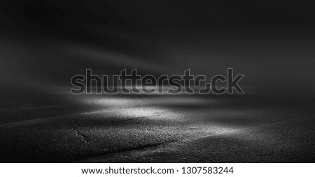 Background of an empty dark street, illuminated by a searchlight. Wet asphalt, a reflection of the night city lights. Neon light smoke