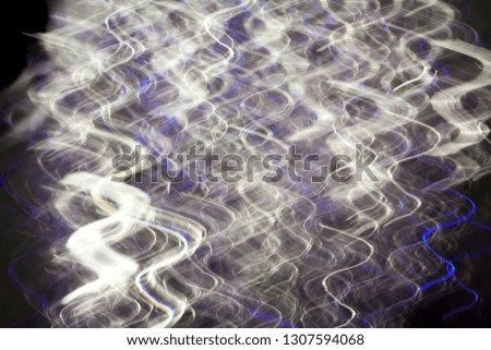 Abstract blurred light effect on a black background. Long exposure photo of moving camera.