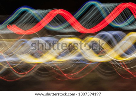 Abstract blurred colorful light effect on a black background. Long exposure photo of moving camera.