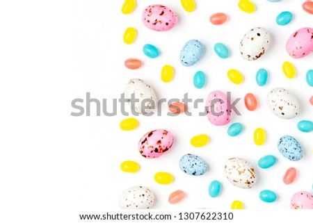 Pattern  made of Easter candy chocolate eggs and Jellybean on white background