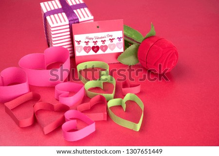 Top view Valentine day of gift red box,with bow and ribbon, with paper heart shape,on plane background, Concept Celebrating festival symbolizes day of love,with copy space for text input. 