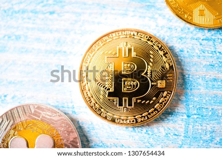 Close up photo of golden Bitcoin, Ripple and Monero coin. Background.