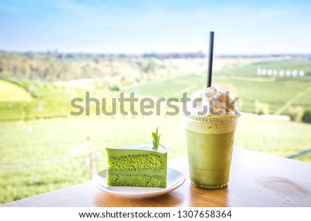 Cake and cold green tea with with tea plantation background. Product from Green tea leaf.