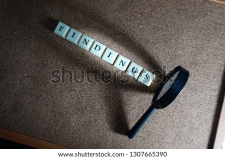 Finding issue conceptual photo using magnifying glass. It involves selective focus, light, shadows and wooden background.