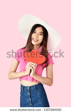 Portrait beautiful Asian girl holding pink heart sign on pink background, happy valentine day concept. Caucasian model