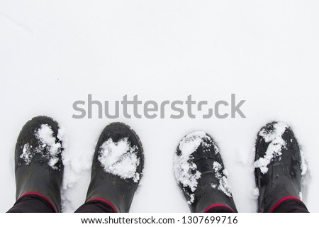 a pair of rubber boots in the snow