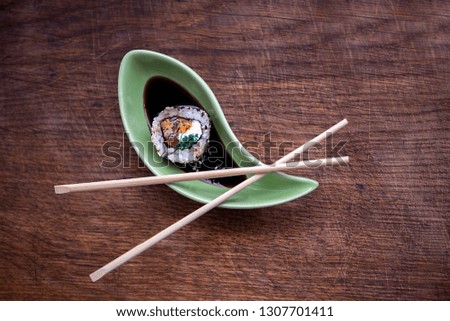 Sushi roll with salmon, mussels and caviar on old textures wooden background. Japanese cuisine. Top view. 