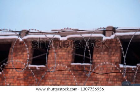 Barbed wire. Brick house under the security