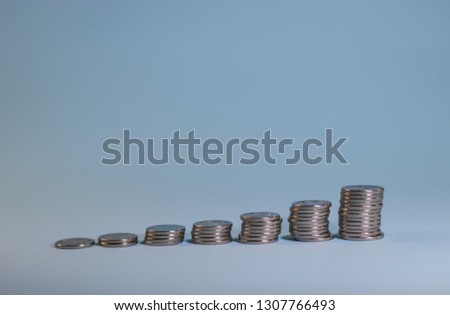 stacks of coins exhibited staircase on a blue background.