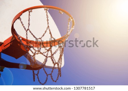 Lone red basketball hoop sitting amidst bright blue skies