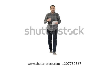 Smiling man with tablet walking and talking to the camera on white background.