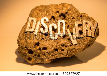 The word Discovery on a rock surface to show the findings of any item really whether it be historic, treasure or for fun.
