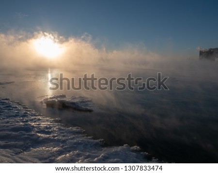 The sun rising over a partially-frozen Lake Michigan with a small iceberg