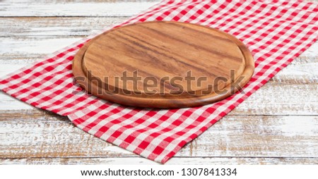 Napkin and board for pizza on wooden desk closeup, tablecloth. Canvas, dish towels on white wooden table background top view mock up. Selective focus