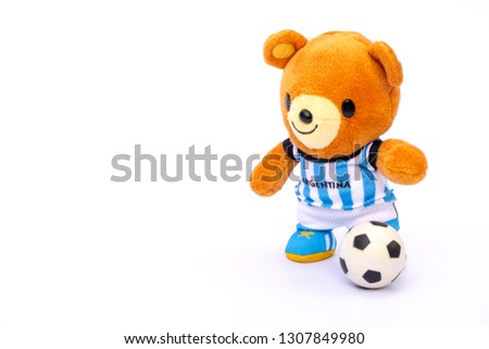 Teddy bear athlete in Argentina dressed player with ball isolated on white background.
