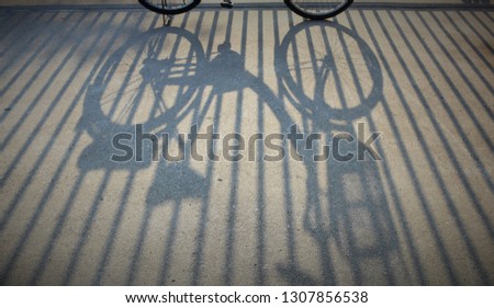 The shadows of the bike and the iron gate in evening.