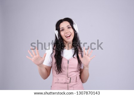 Attractive smiling brunette in white headphones  is dancing boogy style. happy woman listen her favourie music. Internet radio broadcast podcast streaming