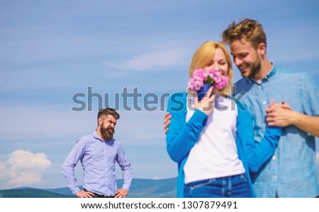Ex partner watching girl starts happy love relations. New love. Couple in love dating outdoor sunny day, sky background. Couple with flowers bouquet romantic date. Ex husband jealous on background. Royalty-Free Stock Photo #1307879491