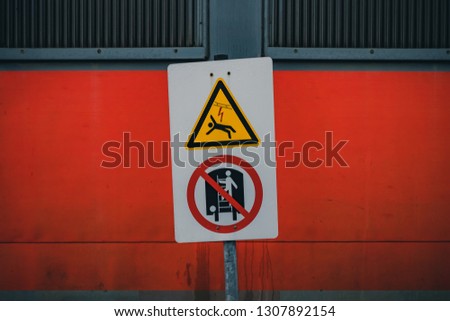 Sign warning to danger of injury and electric shock at a train station.