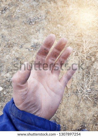 The dirty hands of the worker on the construction site