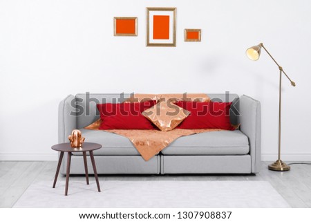 Stylish living room interior with comfortable sofa and orange elements