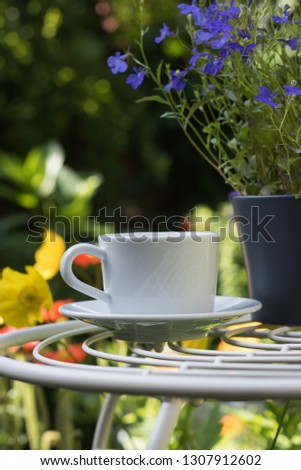 White Cup of Drink is on Beautiful Blurred Background of Colorful Nature in Sunny Spring Day with Copy Space. Concept: Healthy Herbal Tea & Time to Relax. Vertical Image.