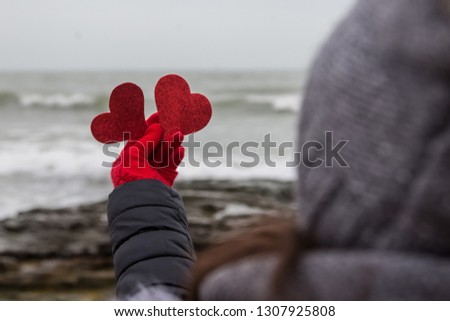 Two red Valentines in the girl's hand.