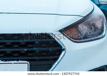 Front icy car headlight. Headlamp in frozen drops