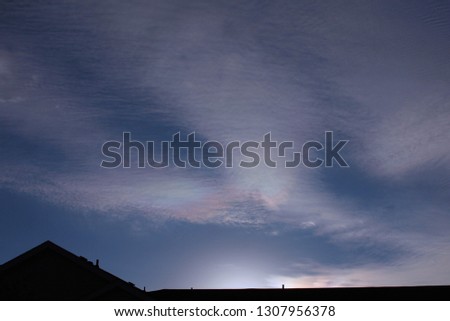 Mixture of Unusual Clouds - photograph of Cirrocumulus clouds with iridescent colors (irisation)and cloud shadows in a blue sky. 