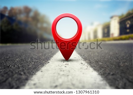 Red GPS pin on asphalt highway background