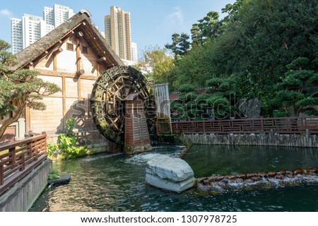 Hong Kong, China. Nan Lian Garden. Government public park situated at Diamond hill, Kowloon. Small mill with high rises in the background.