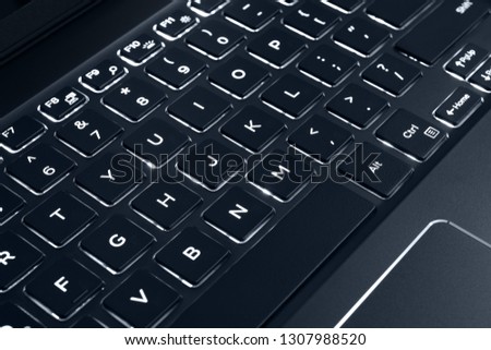 Black backlit computer keyboard, laptop keypad. Panel of keys that operate a computer.