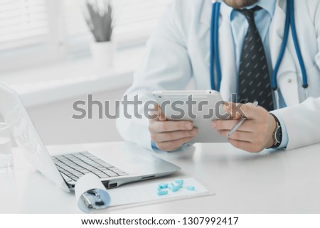 The doctor prescribes a prescription medication sitting in his office