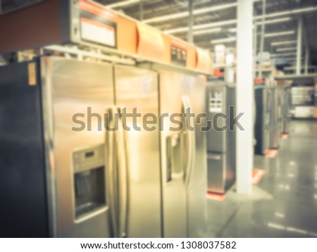 Blurred motion row of brand new refrigerators at home improvement store in America. Variety of stainless steel French door, side-by-side, bottom and top freezer refrigerators