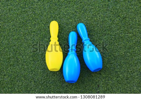 plastic color bowling pin on green grass mattress.