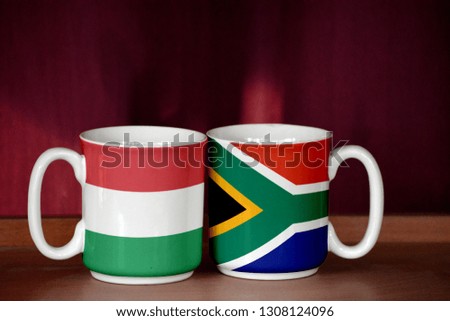 South Africa and Hungary flag on two cups with blurry background